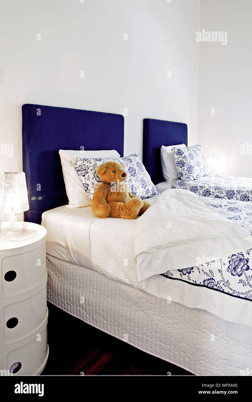 Pair Of Single Beds With Blue Upholstered Headboards In