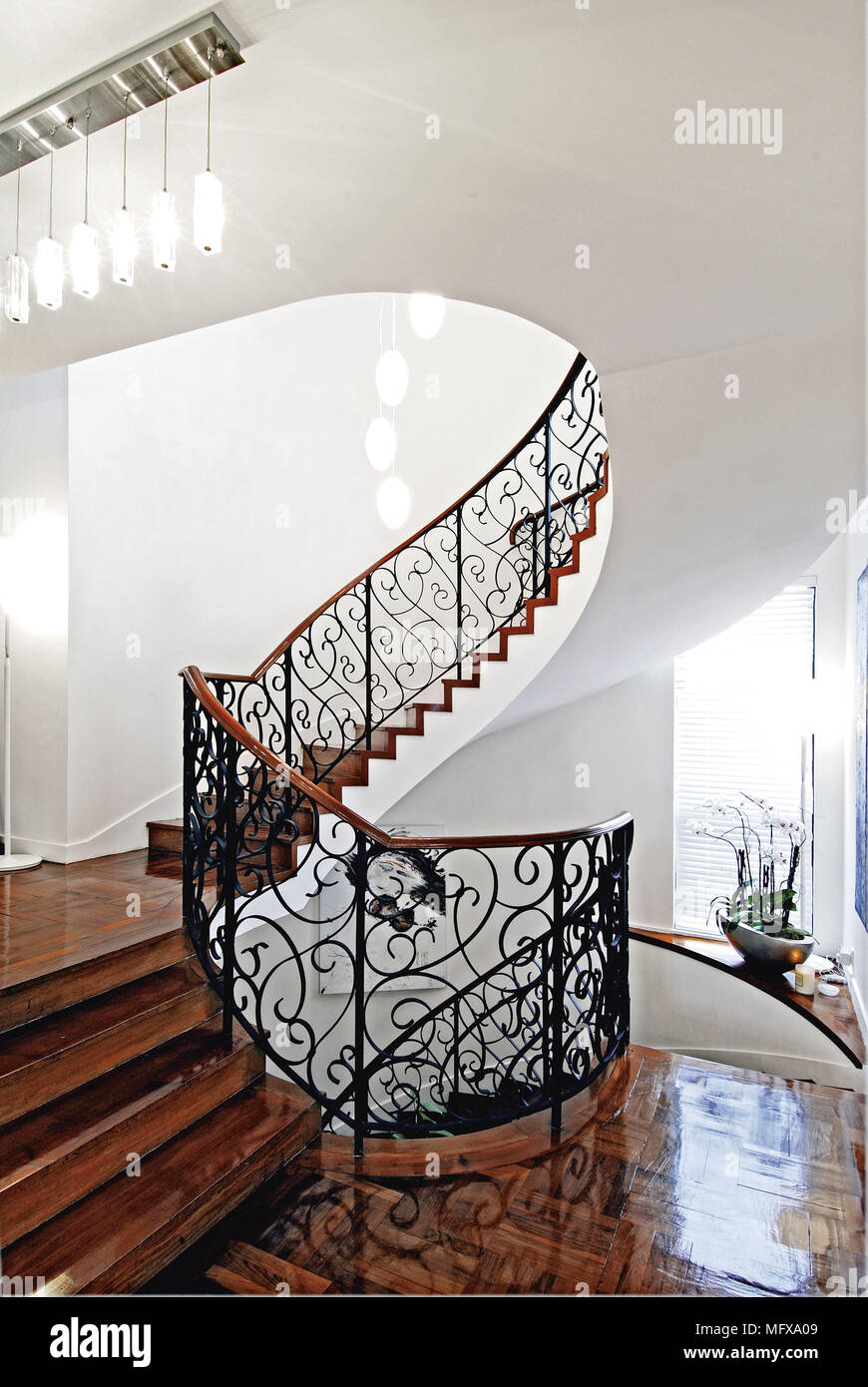 Grand staircase with wrought iron railing and polished wood floor Stock Photo