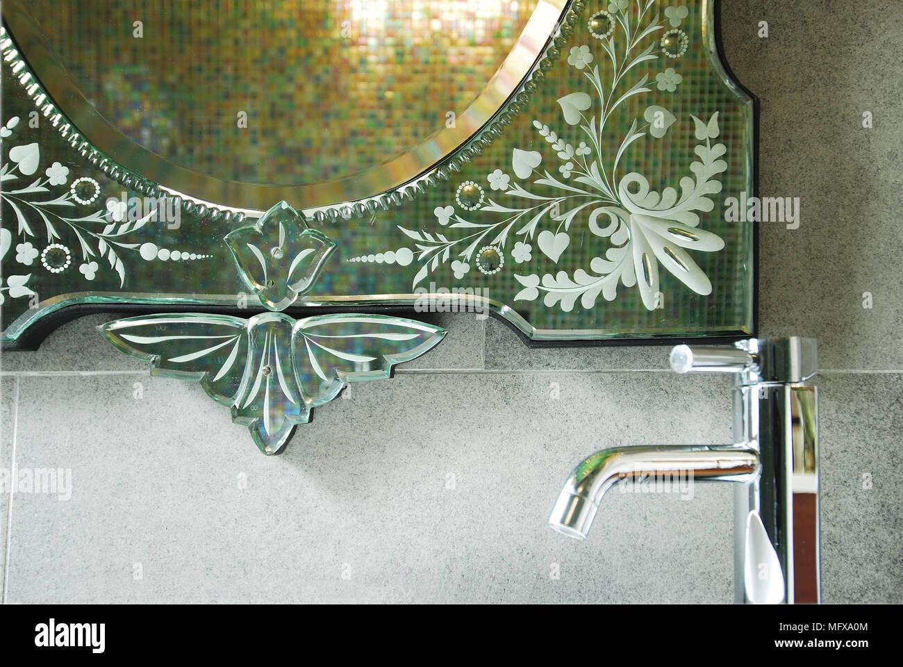 Chrome tap fitting in front of Venetian mirror Stock Photo