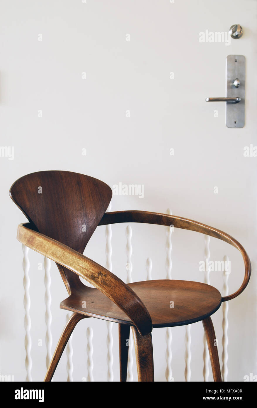 Modern wooden chair in front of door Stock Photo