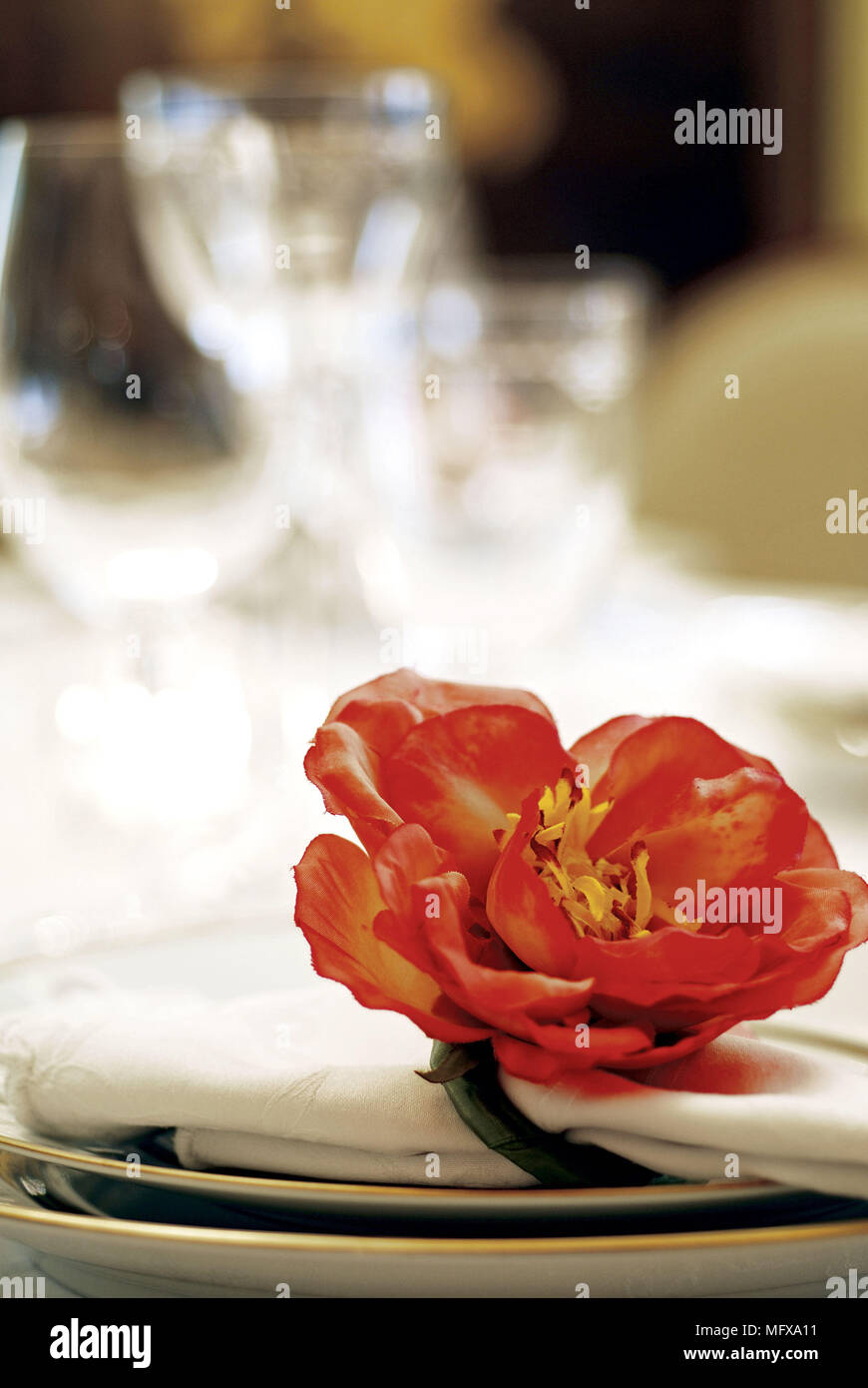 Red flower on napkin on plate Stock Photo