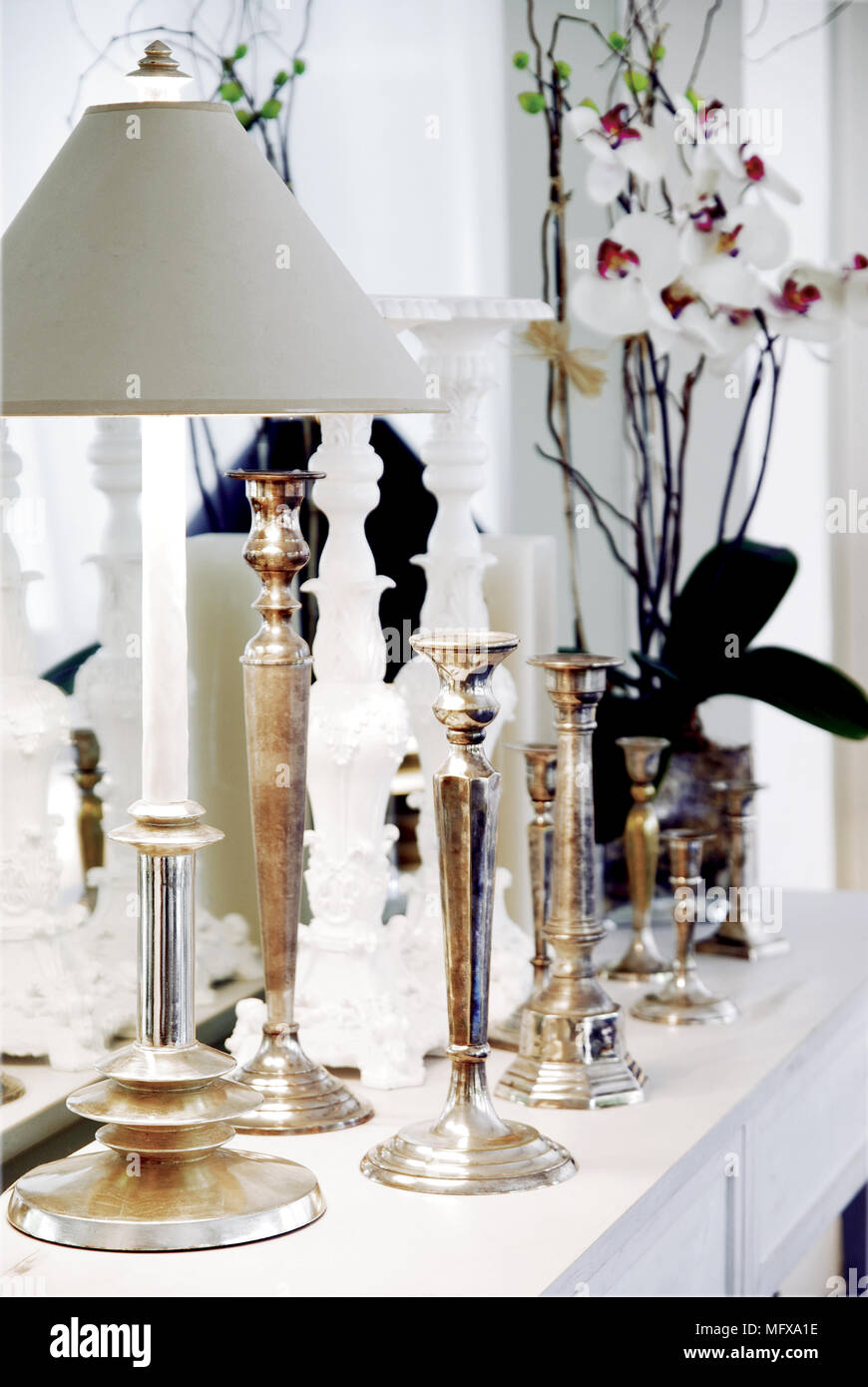 Silver candlesticks and lamp on side table Stock Photo