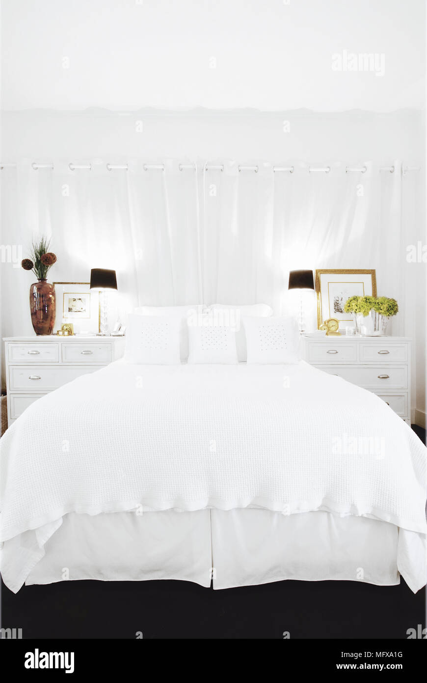 Bedside cabinets either side of double bed in traditional style bedroom Stock Photo