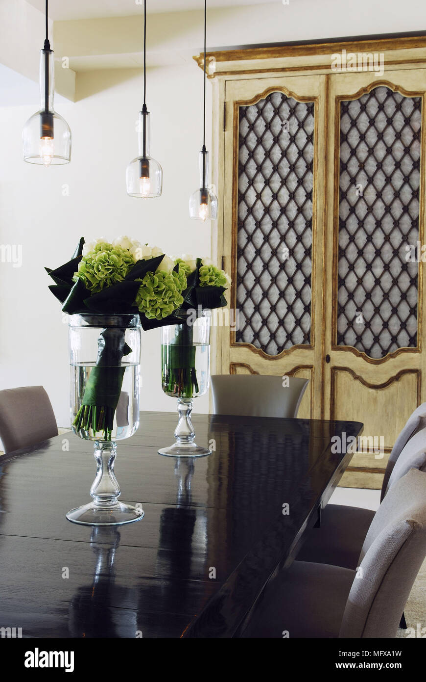 Ceiling lights above table and chairs in modern dining room Stock Photo