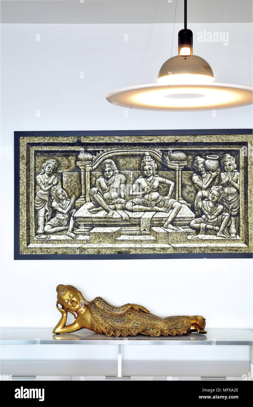 Decorative artwork above reclining eastern figure on table Stock Photo
