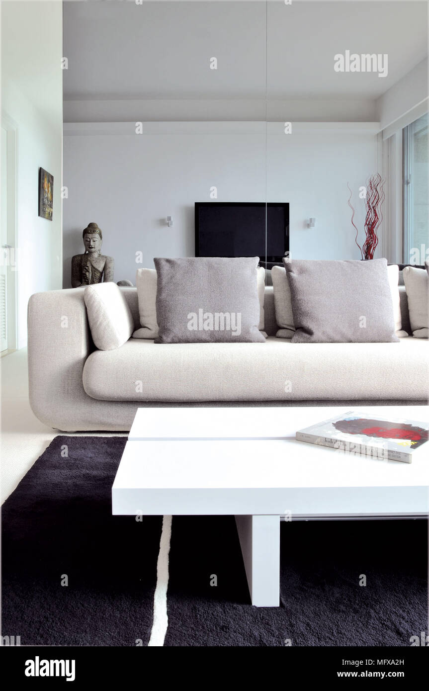 White coffee table in front of upholstered sofa in modern sitting room Stock Photo