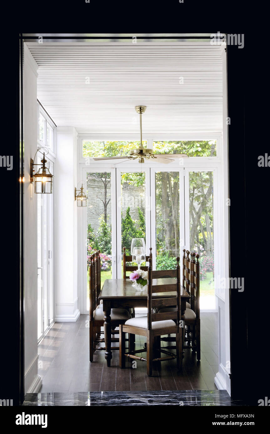 View through open doorway to wooden table and chairs in traditional