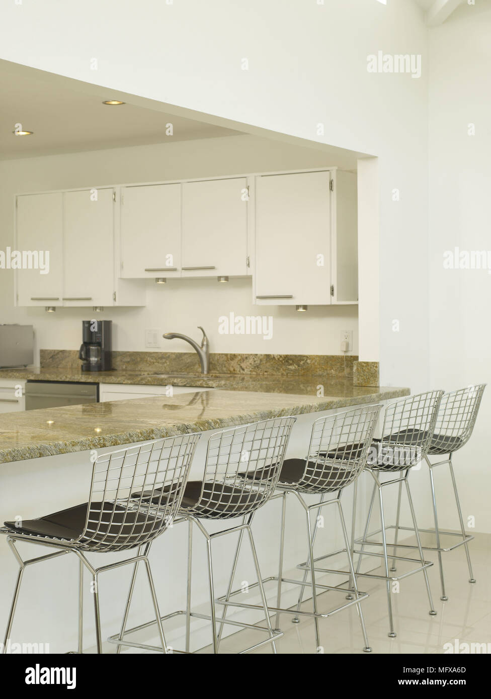 Harry Bertoia wire bar stools at breakfast bar in modern white kitchen  Stock Photo - Alamy