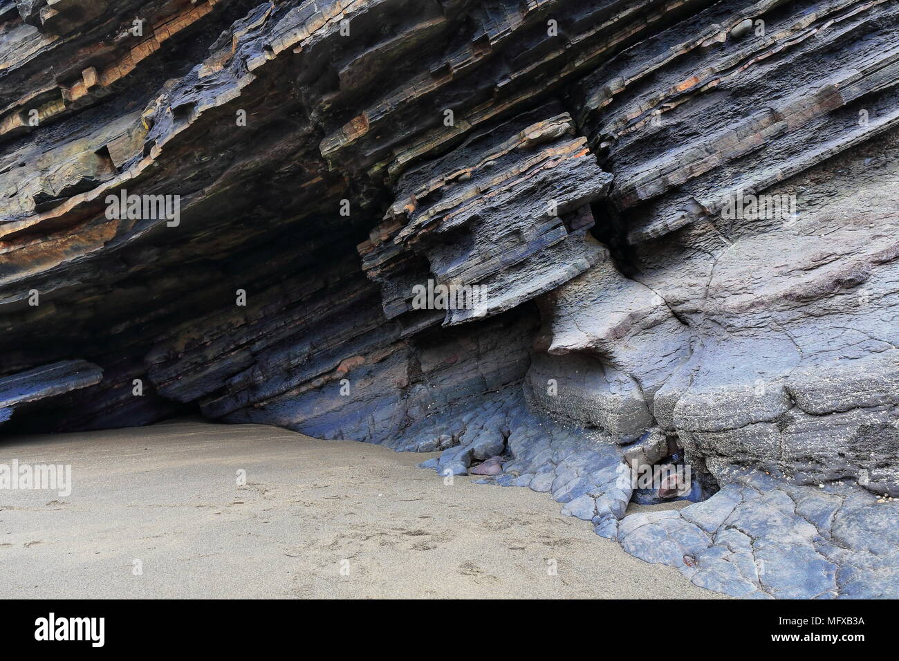 Rock shelter among tilted flysch layersfoot of Gaztelugatxe islet in