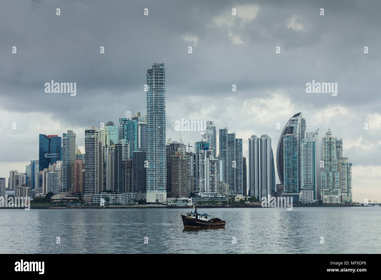 The high-rise buildings of modern Panama City, Panama, with a small fishing boat in the foreground Stock Photo