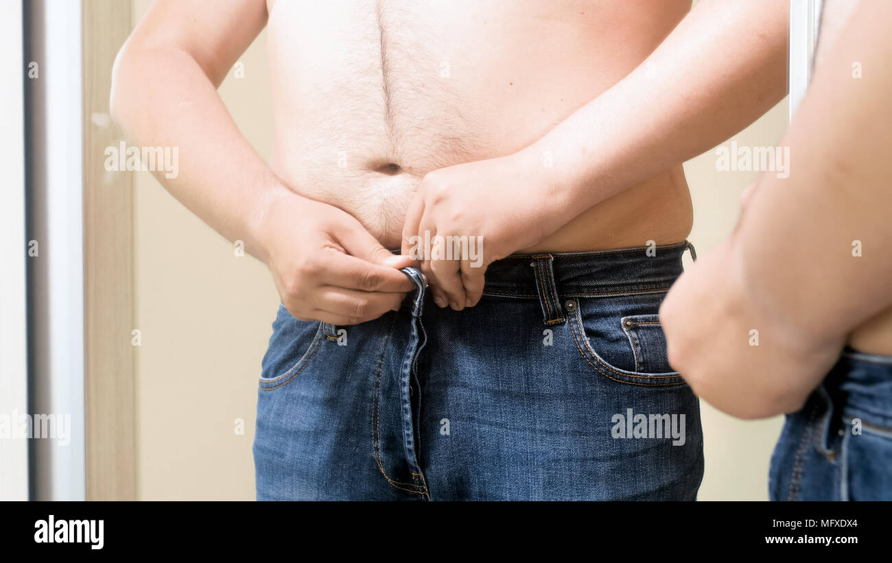 Closeup photo of shirtless fat man wearing tight jeans at mirror Stock  Photo - Alamy