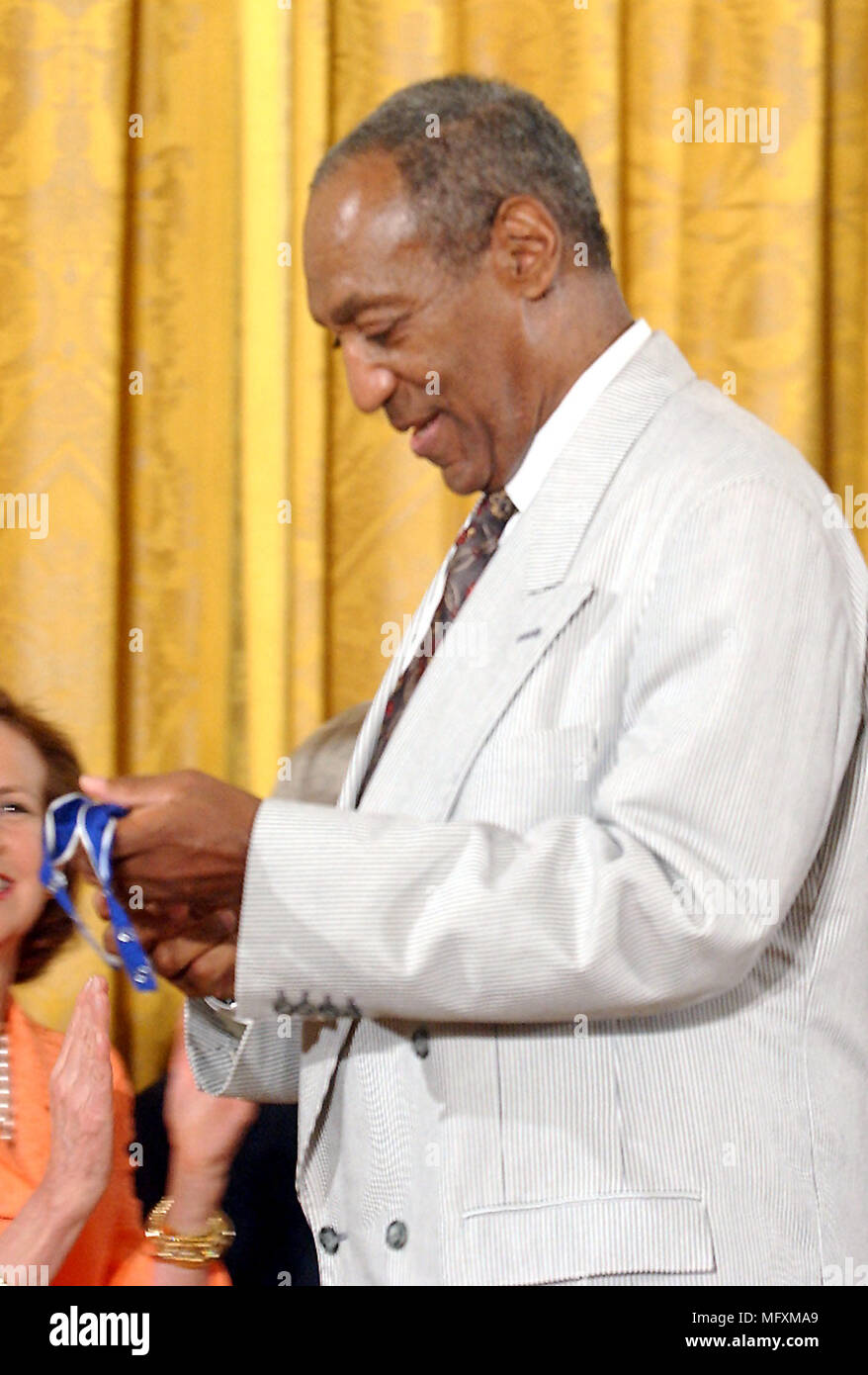 Washington, District of Columbia, USA. 9th July, 2002. Bill Cosby admires his Presidential Medal of Freedom that he received from United States President George W. Bush during a ceremony in the East Room of the White House in Washington, DC on July 9, 2002.Credit: Ron Sachs/CNP Credit: Ron Sachs/CNP/ZUMA Wire/Alamy Live News Stock Photo