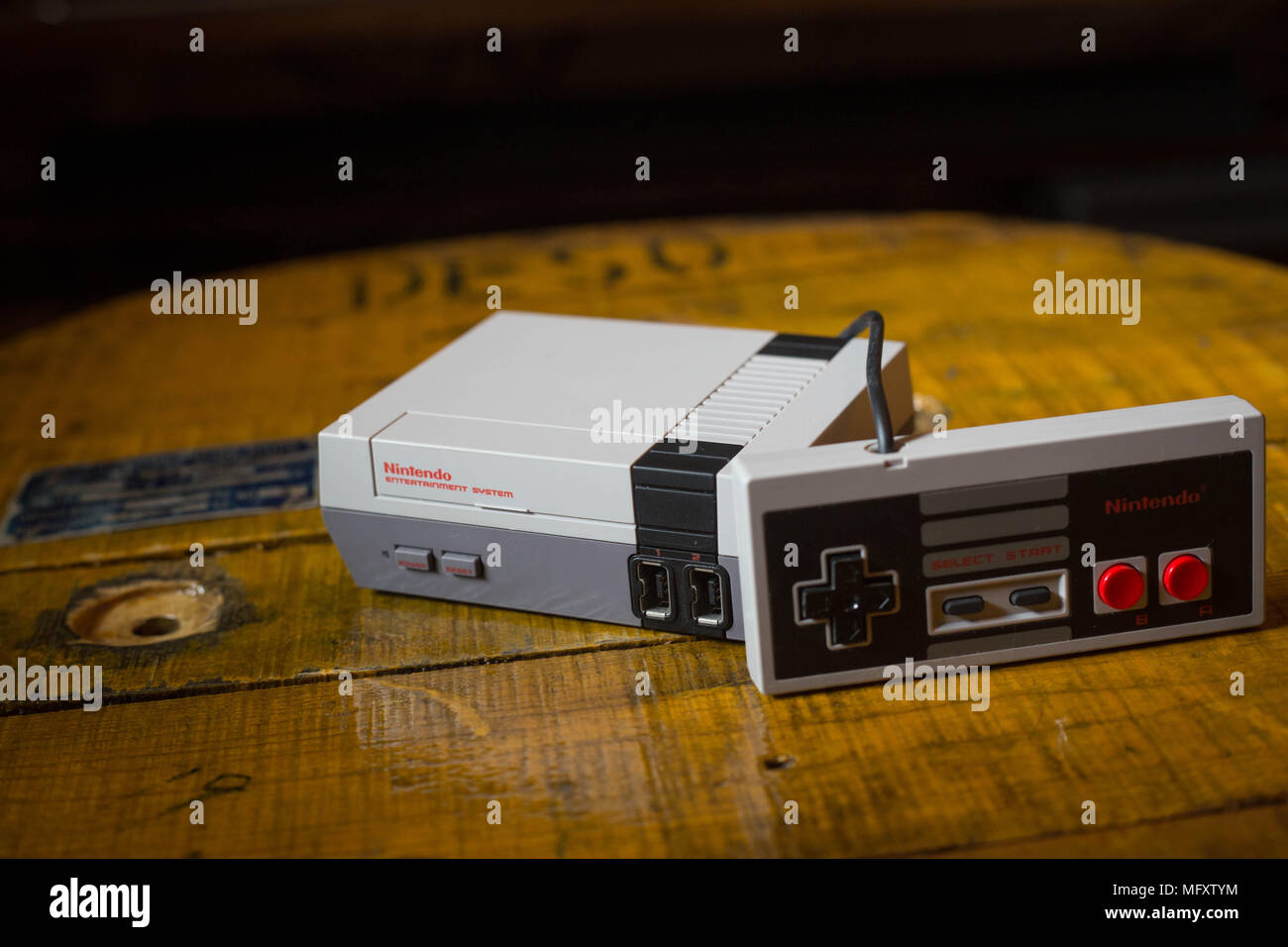 A Nintendo Classic Mini 'Nintendo Entertainment System' video game console with a controller. The Kyoto based video game company Nintendo ended it’s comeback year revenue with worth $9 Billion after a glorious year 2017 notably with the launch of the hybrid console the Nintendo Switch, mini retro vintage game consoles such as the Nintendo Entertainment System and Super Nintendo as well as its mobile phone video games. Stock Photo
