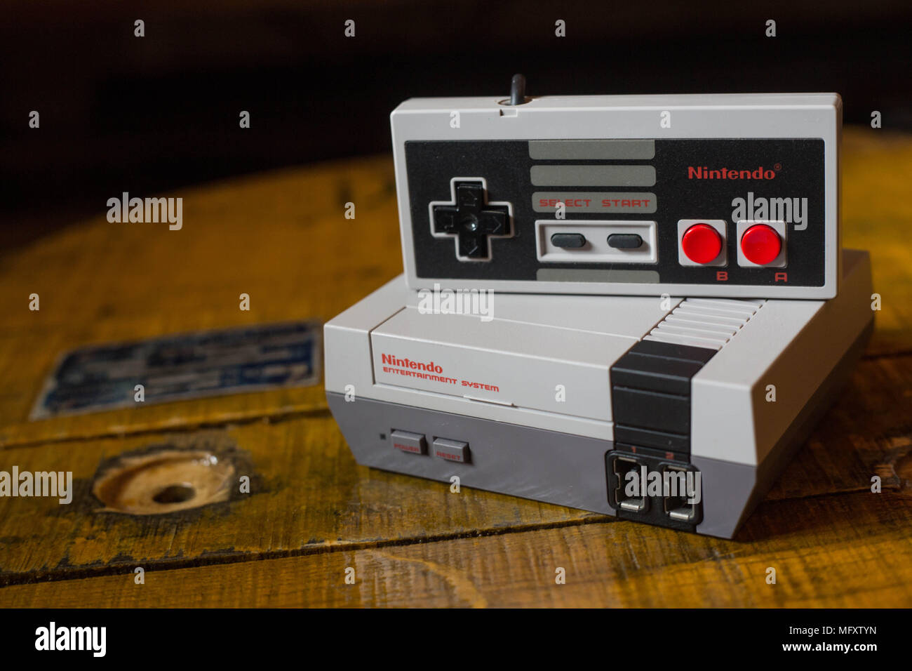 A Nintendo Classic Mini 'Nintendo Entertainment System' video game console with a controller. The Kyoto based video game company Nintendo ended it’s comeback year revenue with worth $9 Billion after a glorious year 2017 notably with the launch of the hybrid console the Nintendo Switch, mini retro vintage game consoles such as the Nintendo Entertainment System and Super Nintendo as well as its mobile phone video games. Stock Photo