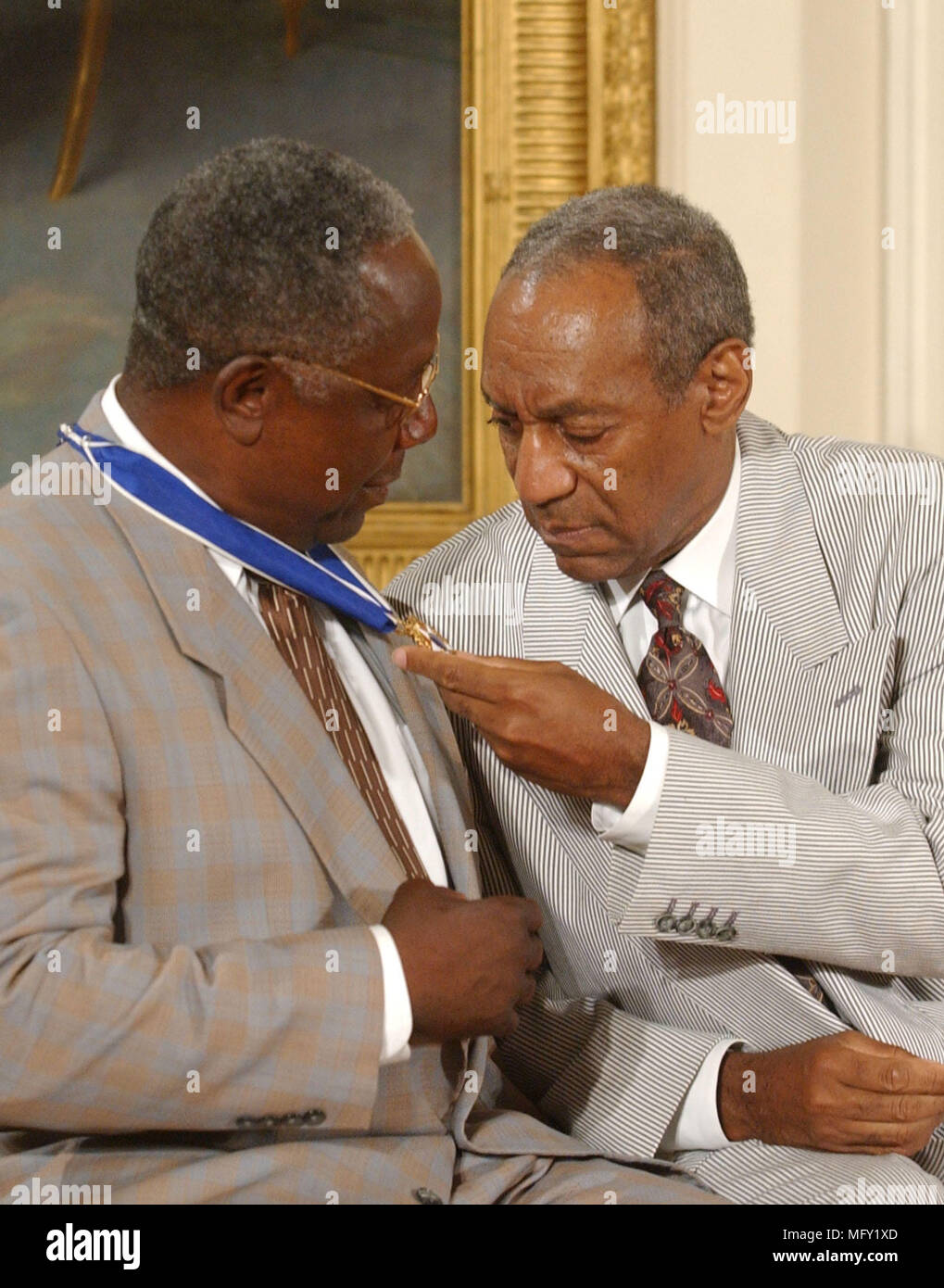 Washington, USA. 09th July, 2002. FILED - Bill Cosby admires Hank Aaron's Presidential Medal of Freedom which was awarded by United States President George W. Bush during a ceremony in the East Room of the White House in Washington, DC on July 9, 2002.Credit: Ron Sachs/CNP - NO WIRE SERVICE · Credit: Ron Sachs/Consolidated News Photos/Ron Sachs/CNP/dpa/Alamy Live News Stock Photo