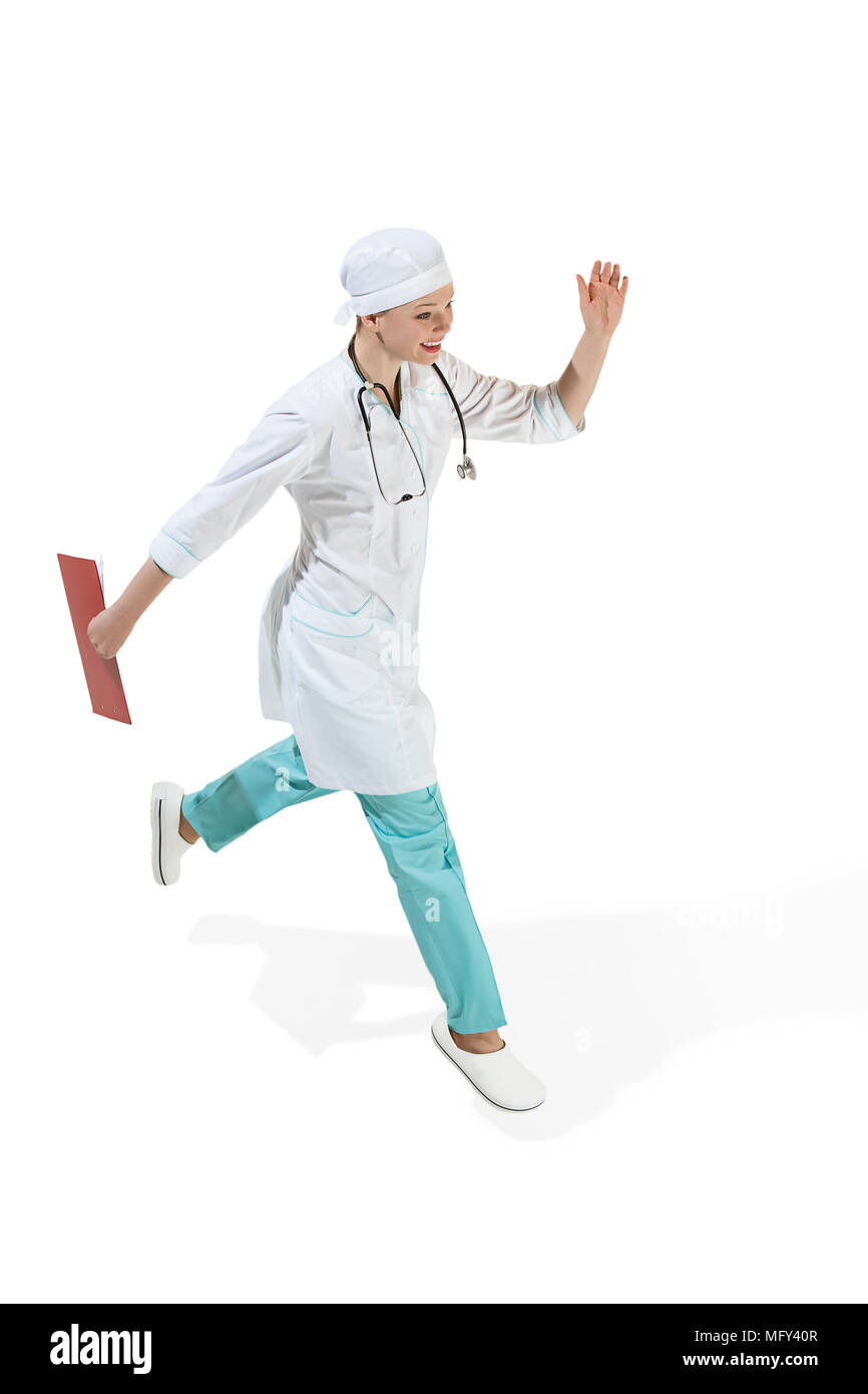 Beautiful young woman in white coat running at studio. Full length