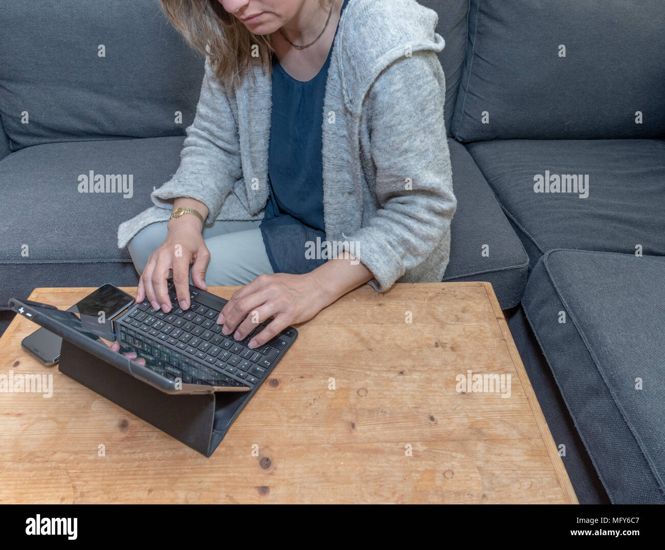 A middle aged woman at home using her laptop computer Stock Photo
