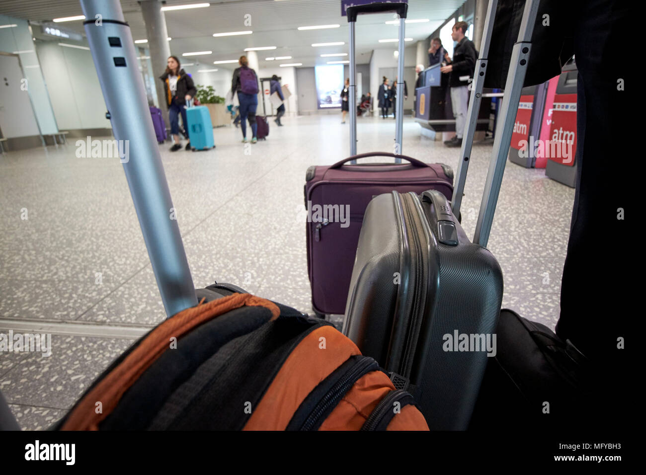 carry on wheeled luggage carried by business people at arrivals bristol