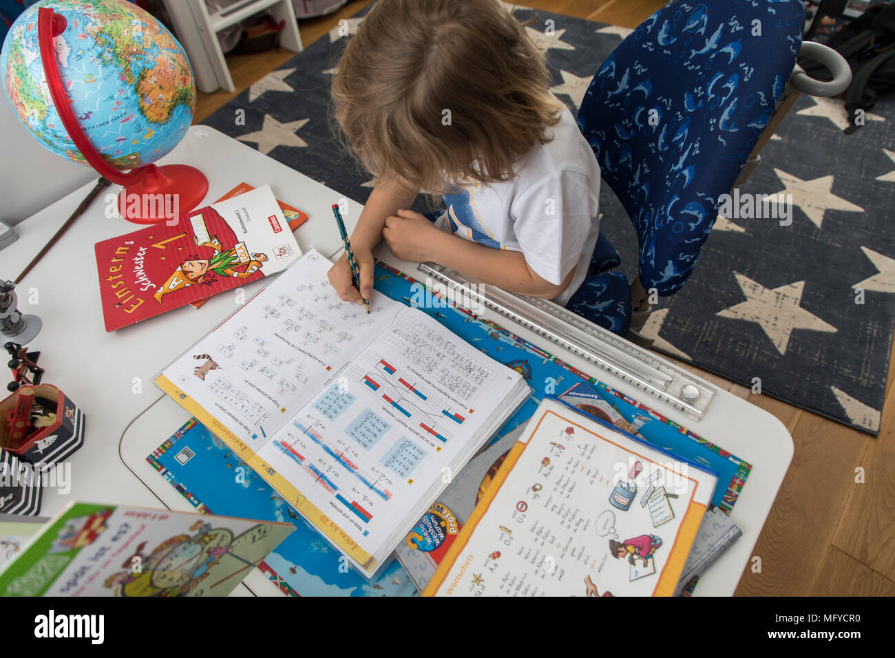 Boy, elementary school student, 8 years old, learns for school at home, does homework, Mathematics, Stock Photo