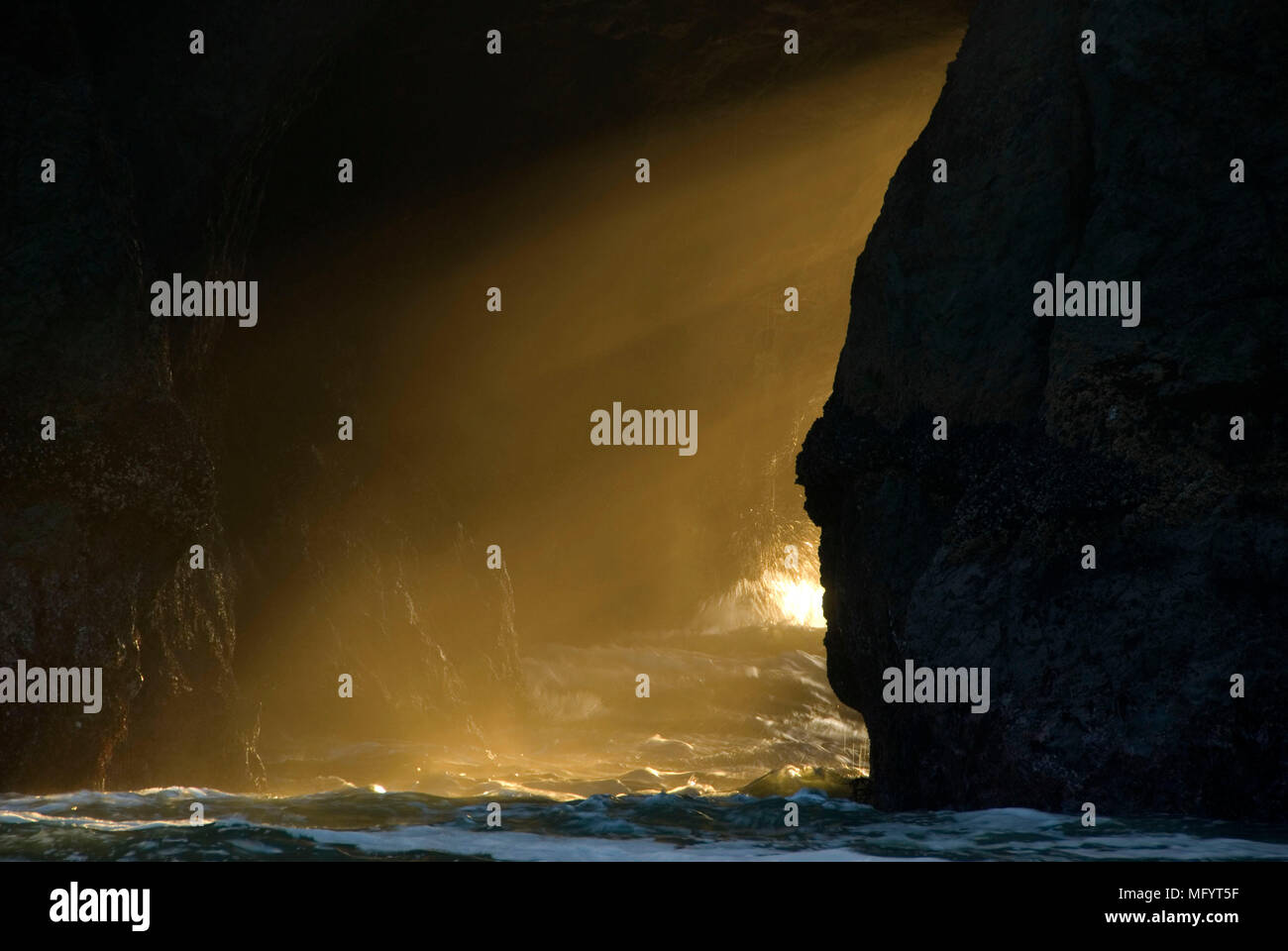 Lightrays through sea arch, Bandon State Park, Oregon Stock Photo