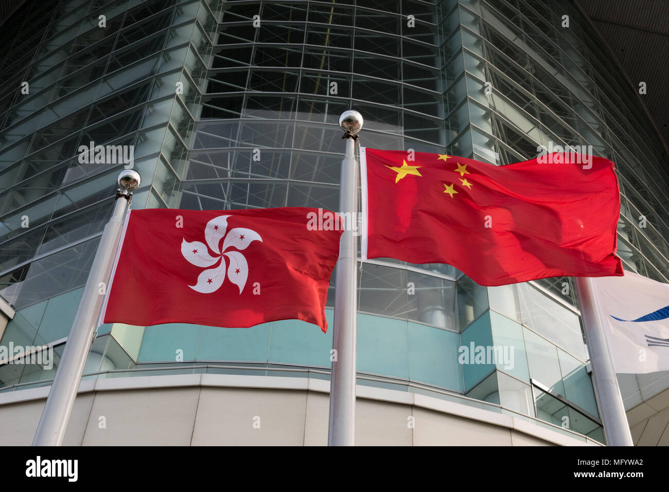 The Hong Kong (L) and Chinese flag fly side by side in exhibition square by the waterfront at the Hong Kong Convention and Exhibition Centre Wan Chai Stock Photo