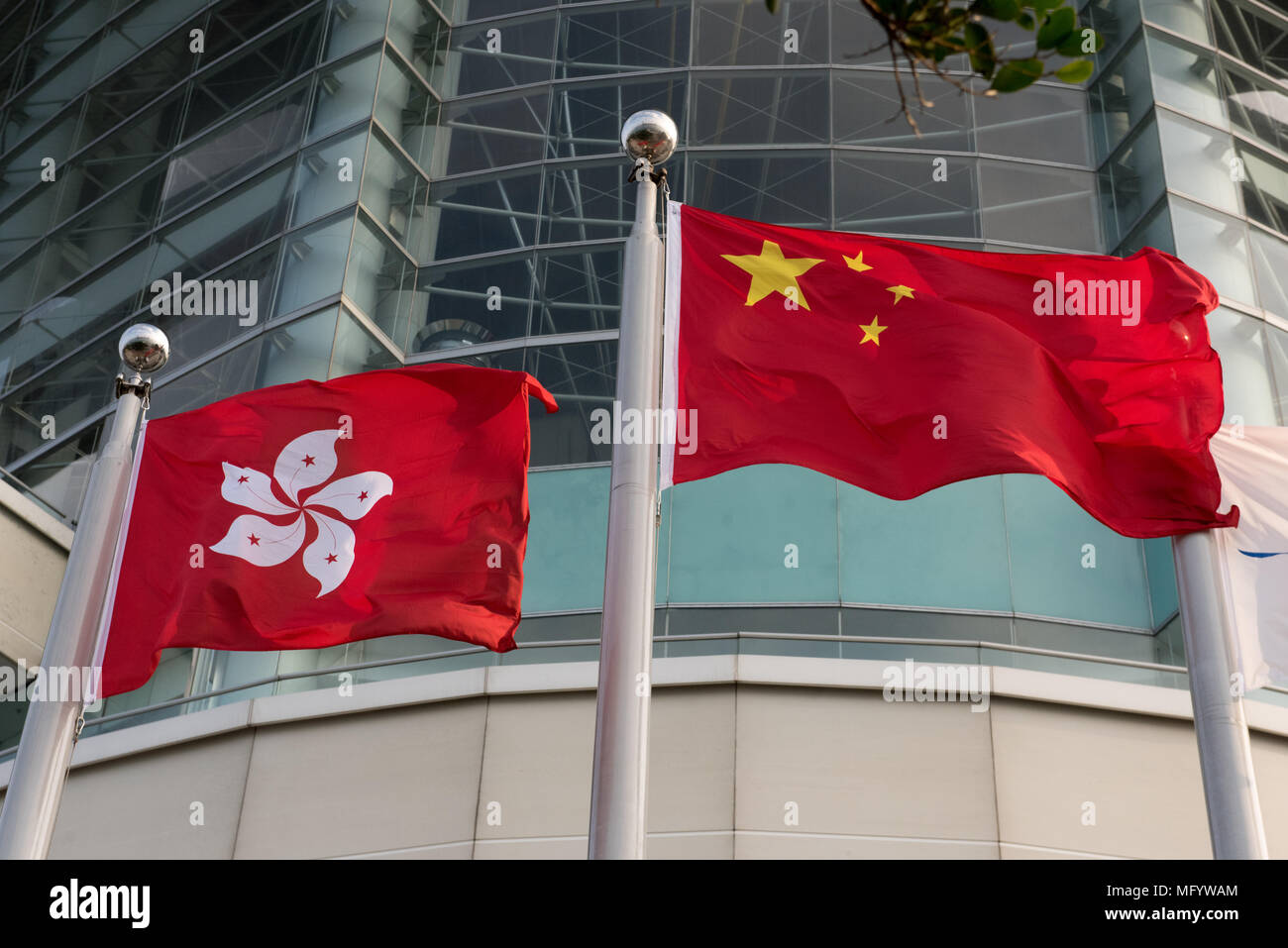 The Hong Kong (L) and Chinese flag fly side by side in exhibition square by the waterfront at the Hong Kong Convention and Exhibition Centre Wan Chai Stock Photo