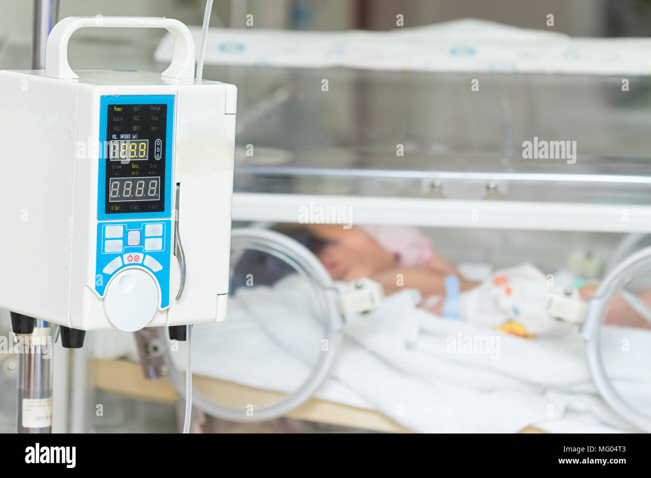 Infusion pump intravenous IV drip into baby's patients background Stock