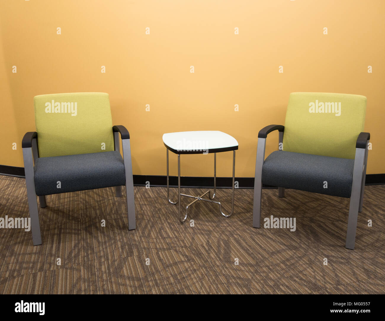 Two chairs and a side table in a business waiting area Stock Photo