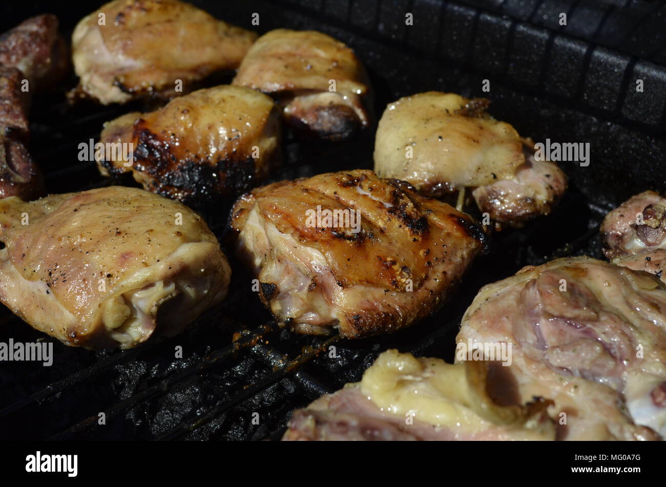 Fresh and juicy Chicken Thighs cooking on the outdoor backyard BBQ grill Stock Photo