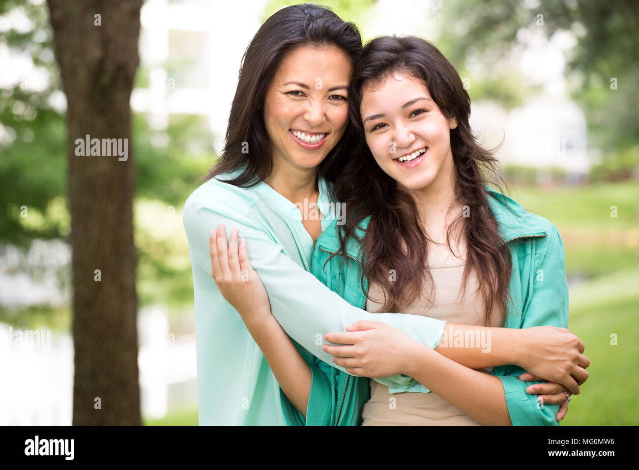 Asian mother laughing and huging her child. Stock Photo