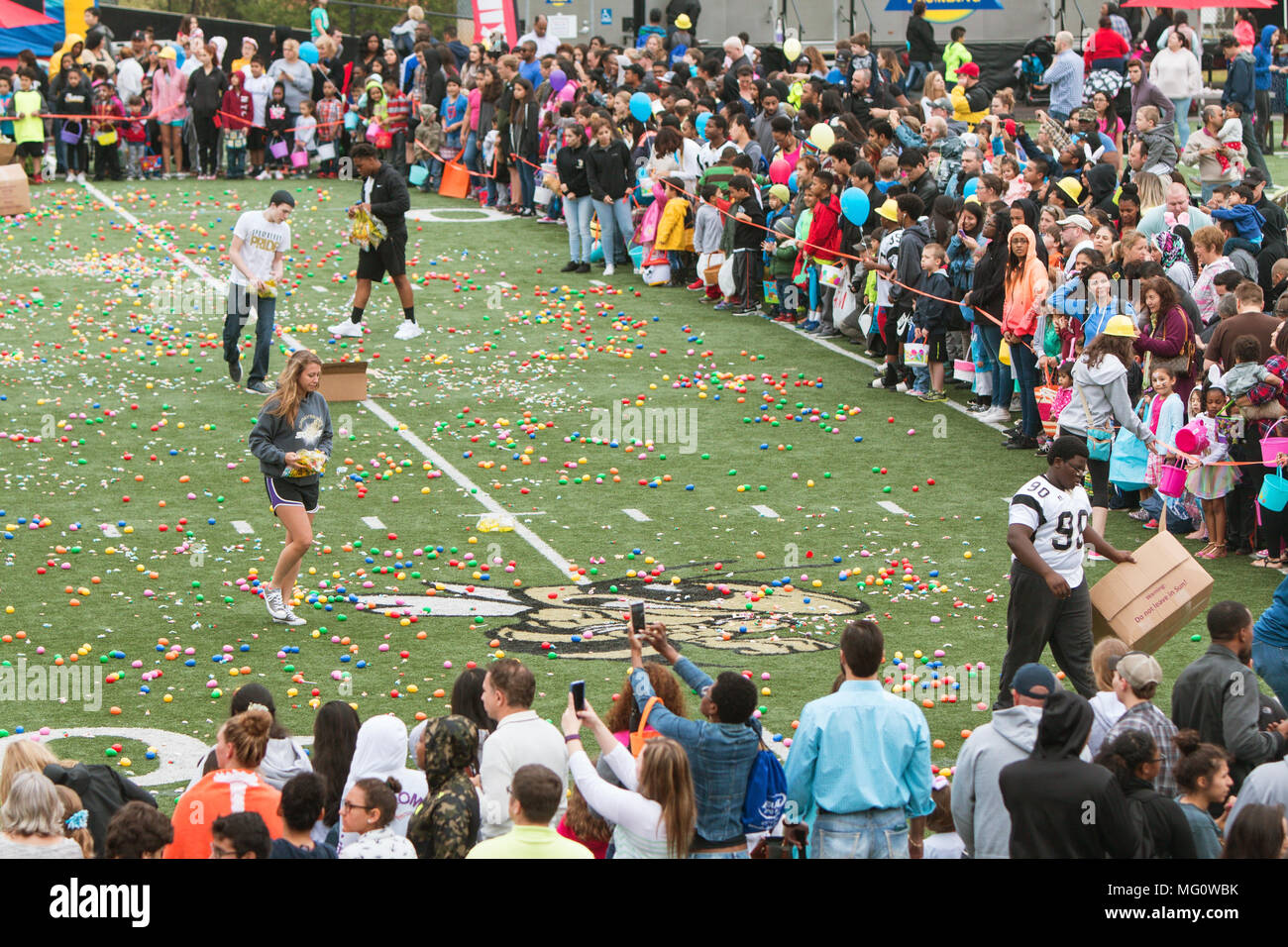 Teen volunteers cover a high school football field with plastic easter eggs and candy at Sprayberry High School on March 26, 2016 in Marietta, GA. Stock Photo