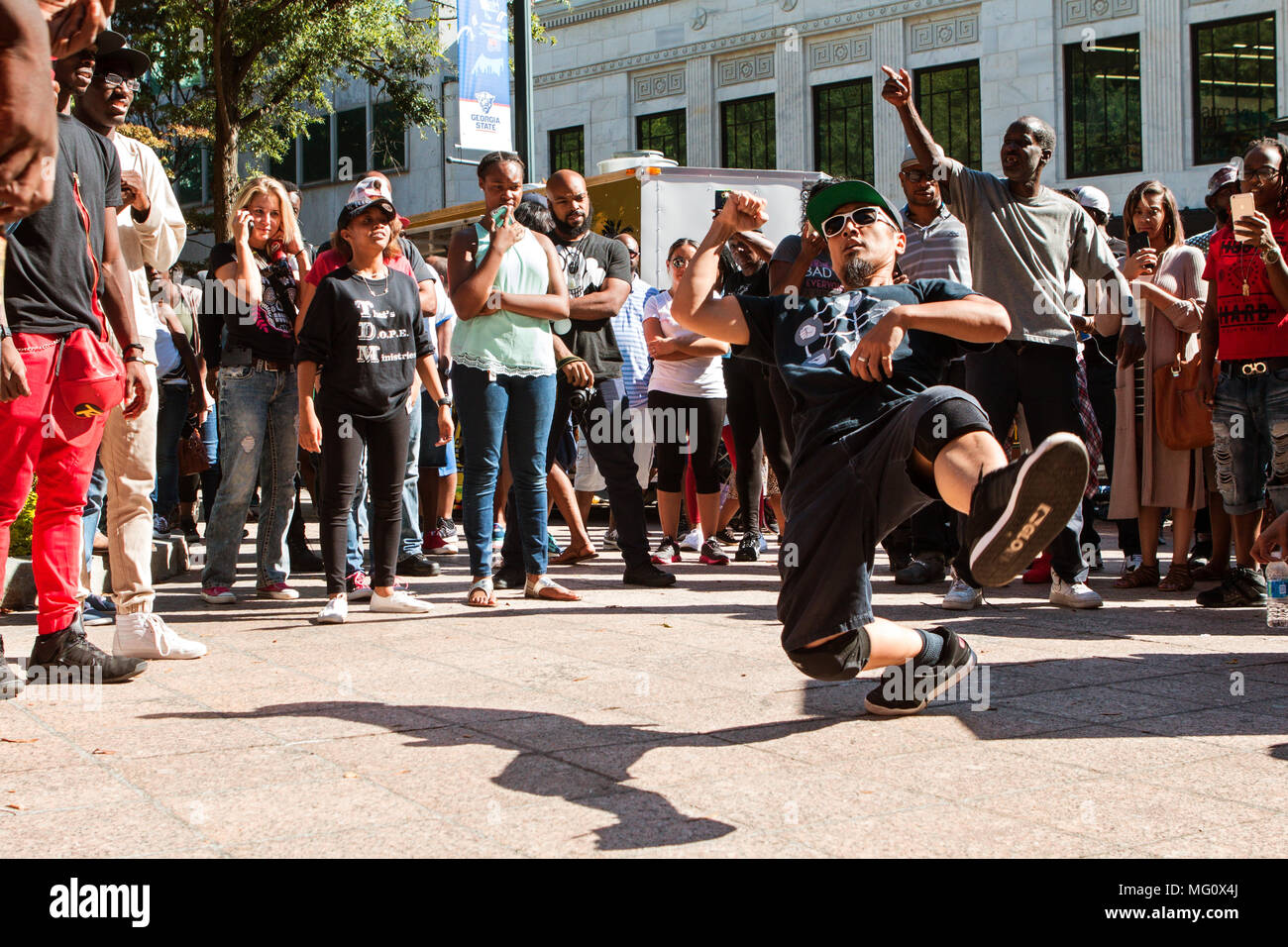 A young man spontaneously break dances as spectators watch, as part of a b-boy battle at Atlanta Hip Hop Day on October 8, 2016 in Atlanta, GA. Stock Photo