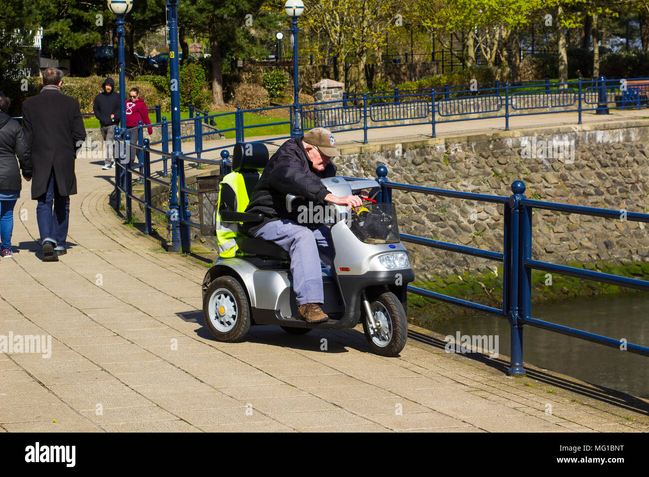 26 April 2018 A 94 year old senior citizen out and about on a disability scooter  at the seafront in Bangor Northern Ireland on a cold but bright and Stock Photo