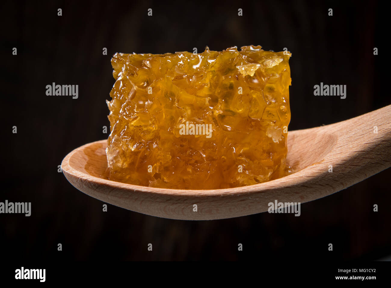 Block of Honey Comb In Spoon against dark background Stock Photo - Alamy
