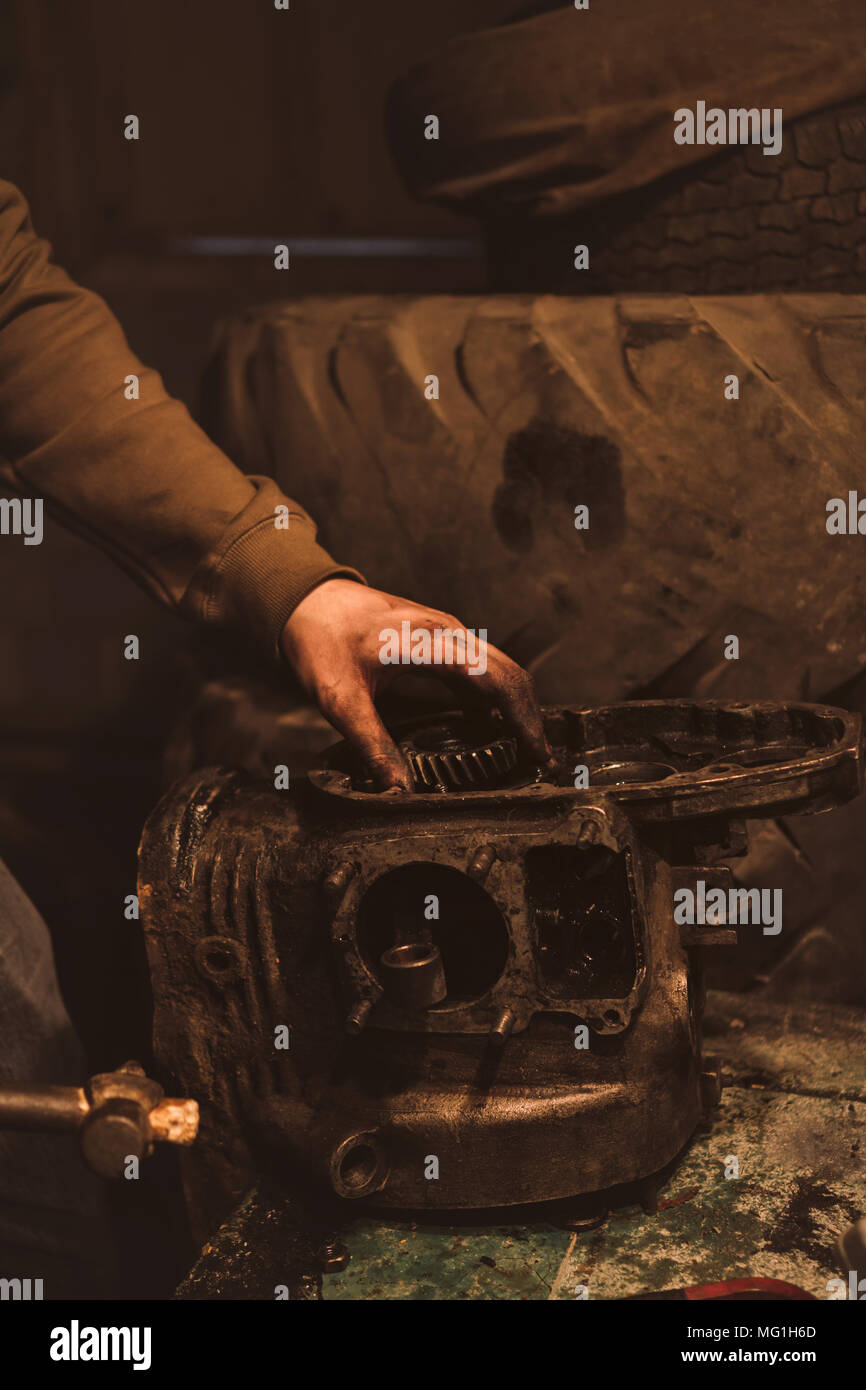 Motorcycle engine disassembly. Man knocks rusty detail with a hammer