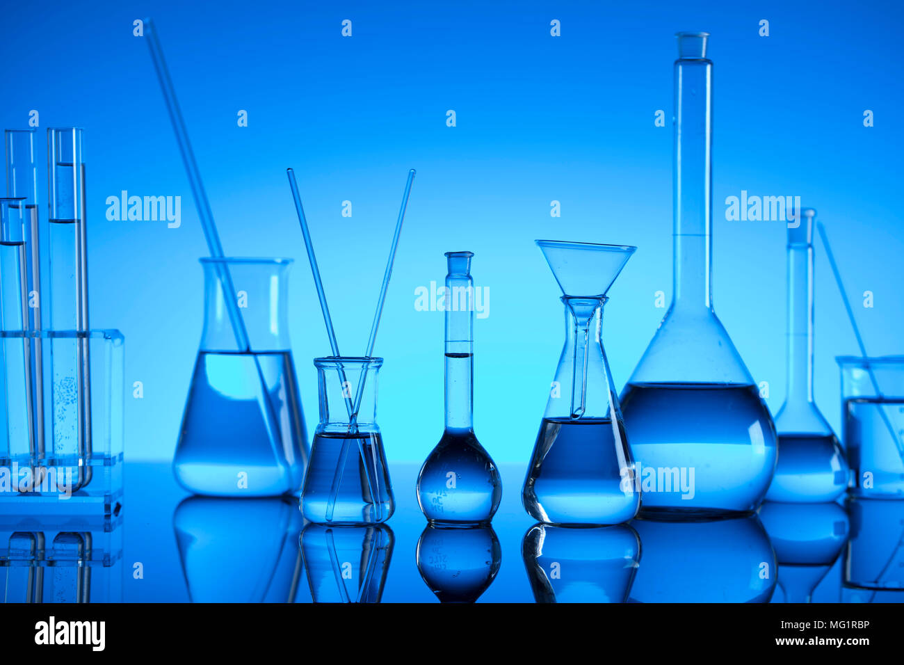 Chemical laboratory concept. Experiment with liquids. Laboratory glassware  and microscope. Blue background. Place for logo Stock Photo - Alamy