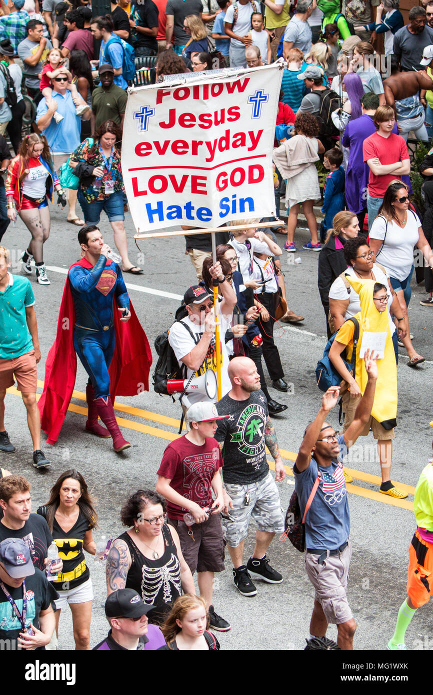 A man carrying a religious sign uses a bullhorn to preach to spectators at the Dragon Con Parade on September 3, 2016 in Atlanta, GA. Stock Photo