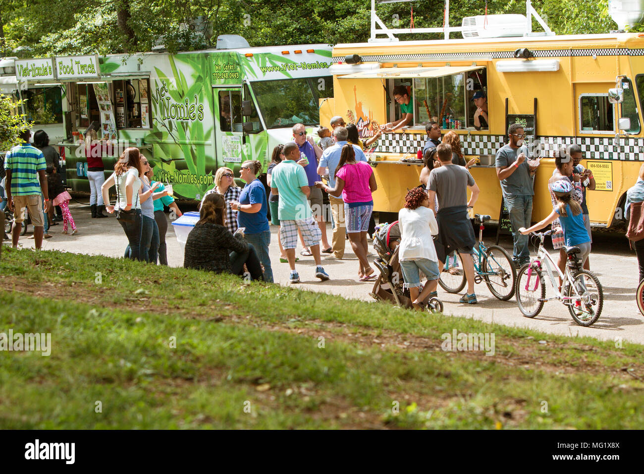 A Large Crowd Of People Buy Meals From Food Trucks Lined Up