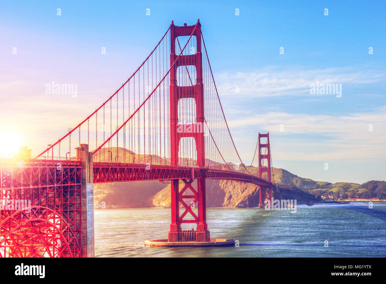 Scenic view of the Golden Gate Bridge in San Francisco, California, during early evening sunset with deliberate lens flare. The landmark bridge is one Stock Photo