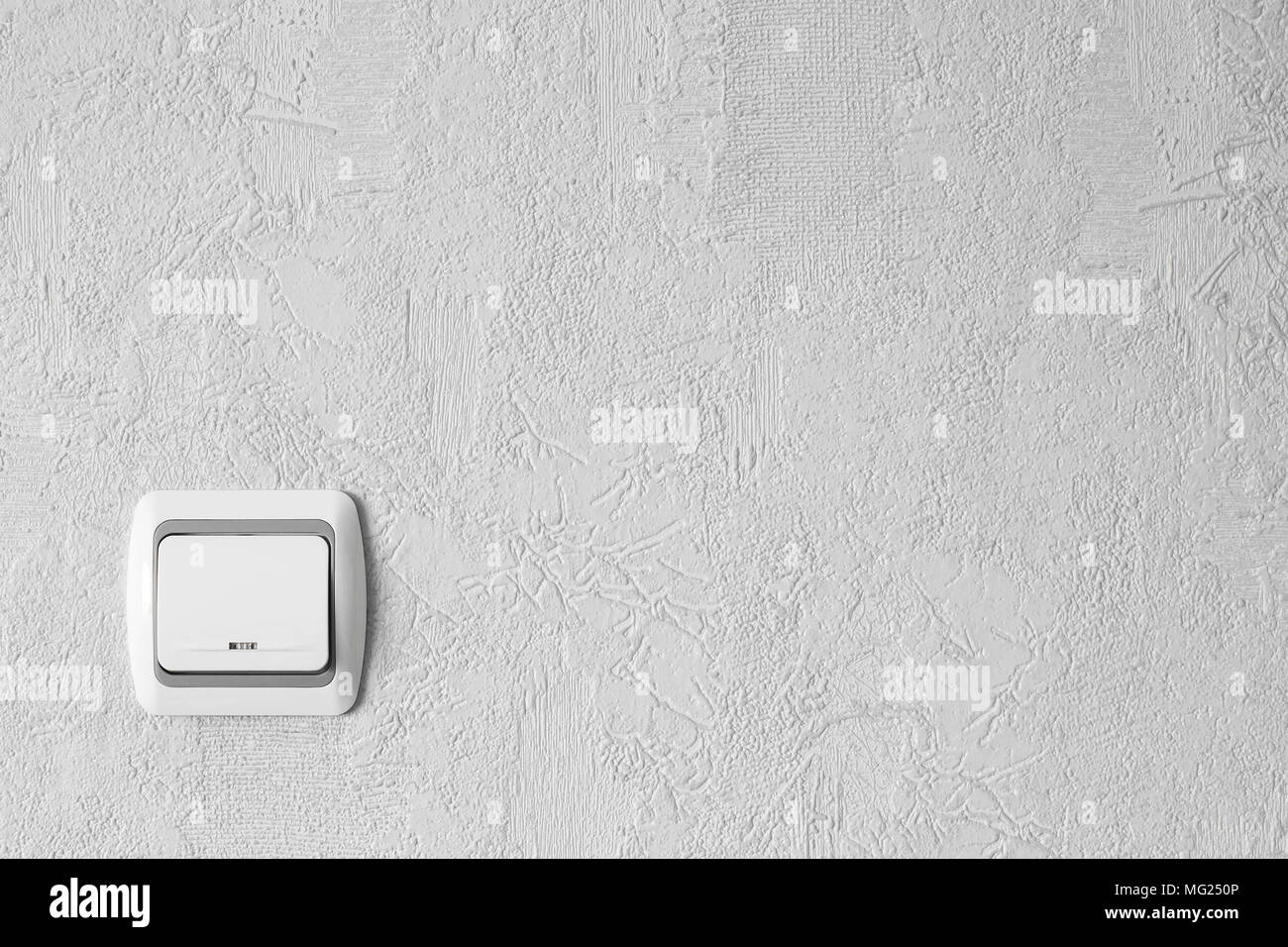 White light switch on a wall. Light switch with copy space. Minimalism. Concept. Background. Stock Photo