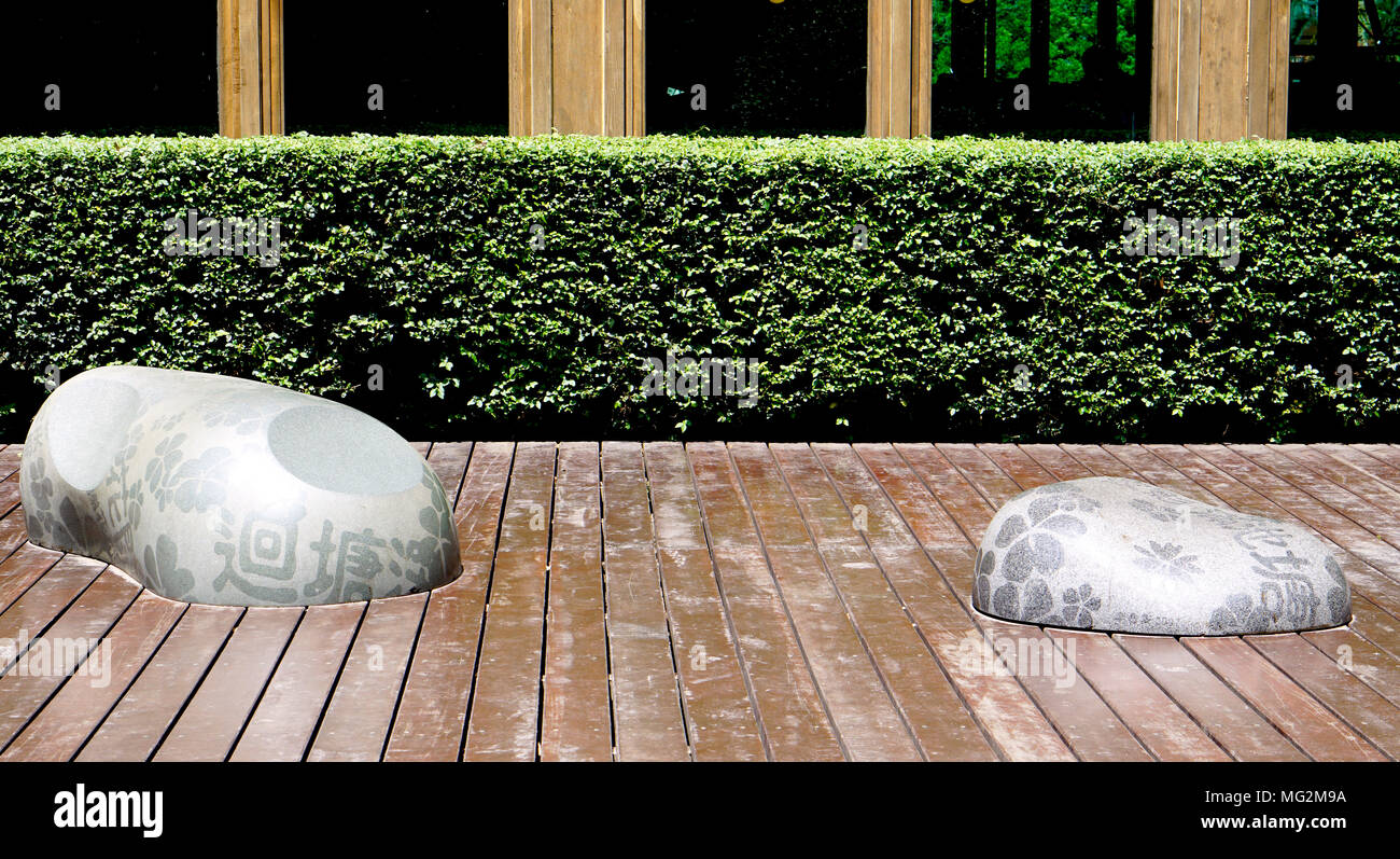 free form stone seating on wood terrace in the garden in Beitou, Taipei, Taiwan Stock Photo
