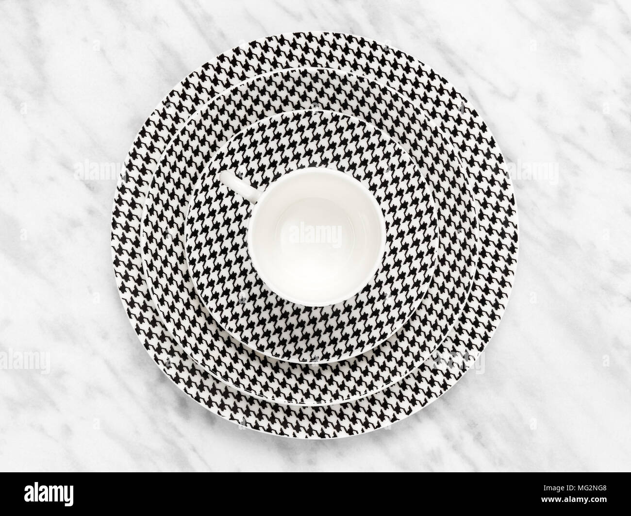 Black and white coffee cup with a set of saucers on marble background