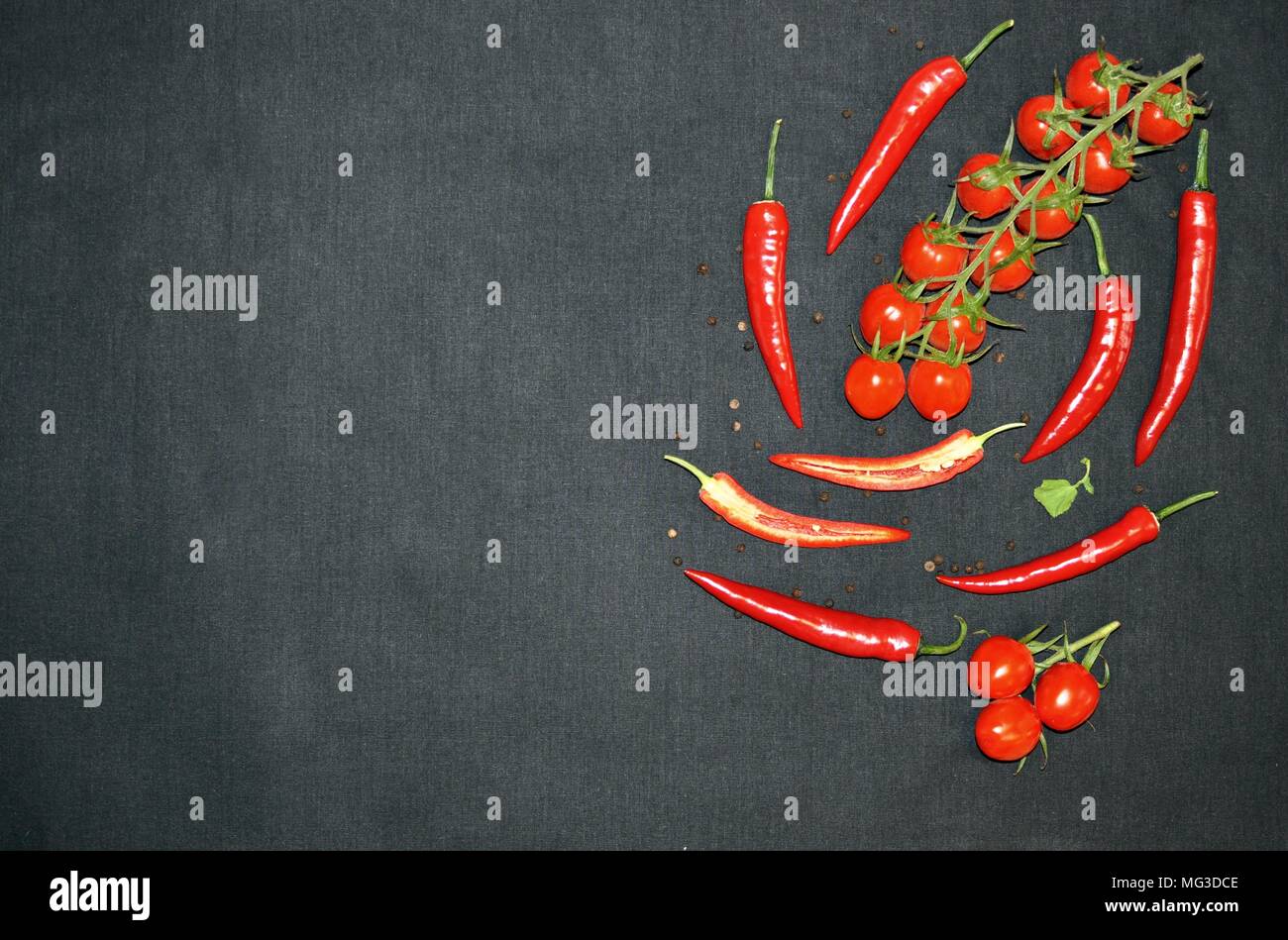 Bunch of cherry, hot chilli and pepper on black background, top view, minimalist style, copy space Stock Photo