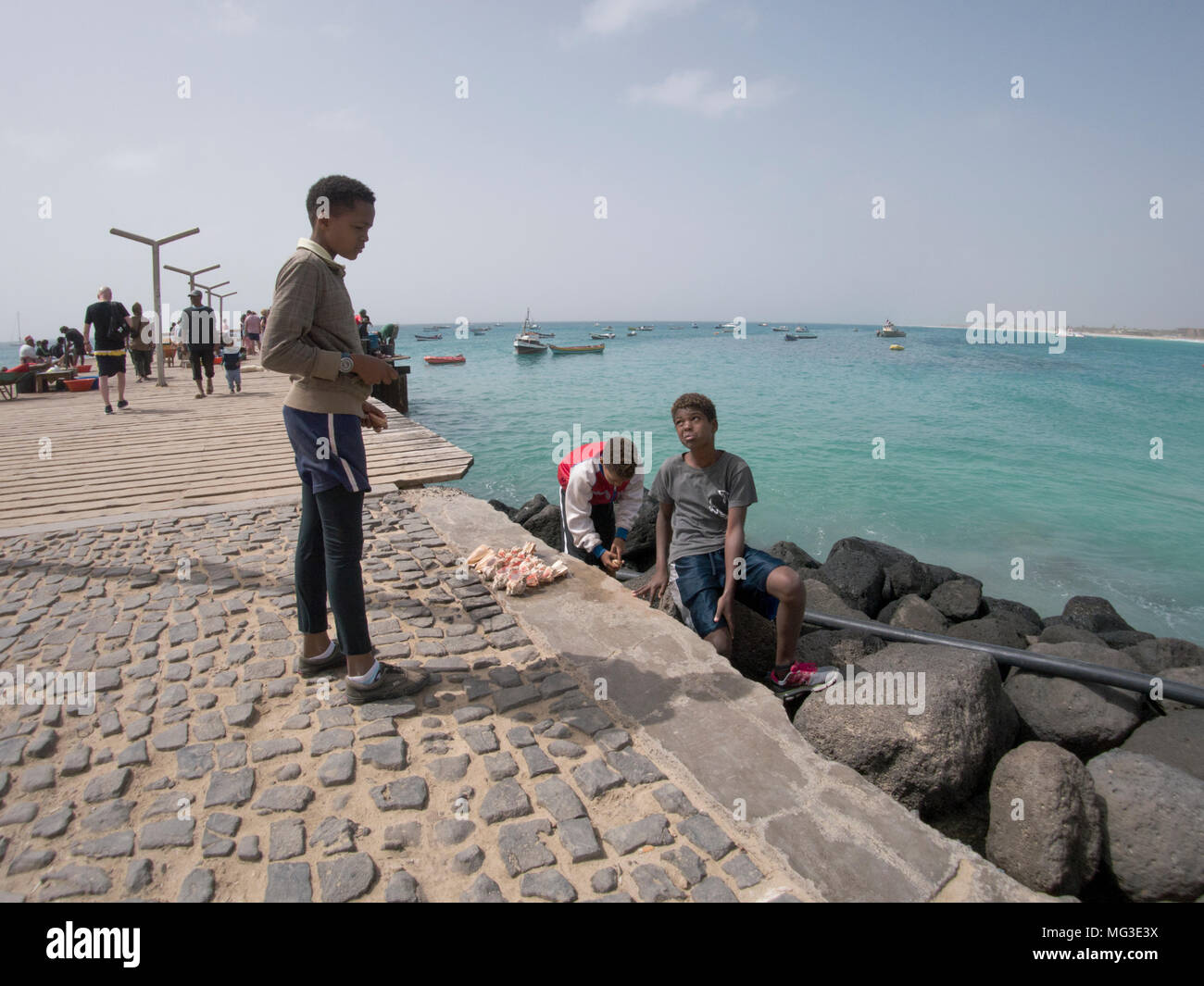 Boys selling sea shell souvenirs on Santa Maria pier Sal Island Cape Verde Islands Stock Photo