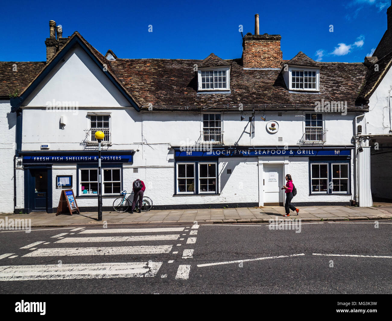 Loch Fyne restaurant  - pedestrian passes the Loch Fyne restaurant in Cambridge UK. Part of an upmarket chain specialising in fresh seafood dishes. Stock Photo