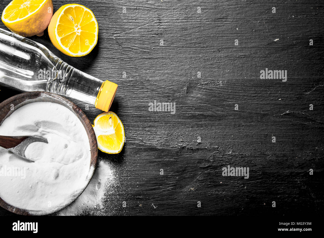 Baking soda in a bowl with vinegar and lemon slices. On the black chalkboard Stock Photo Alamy