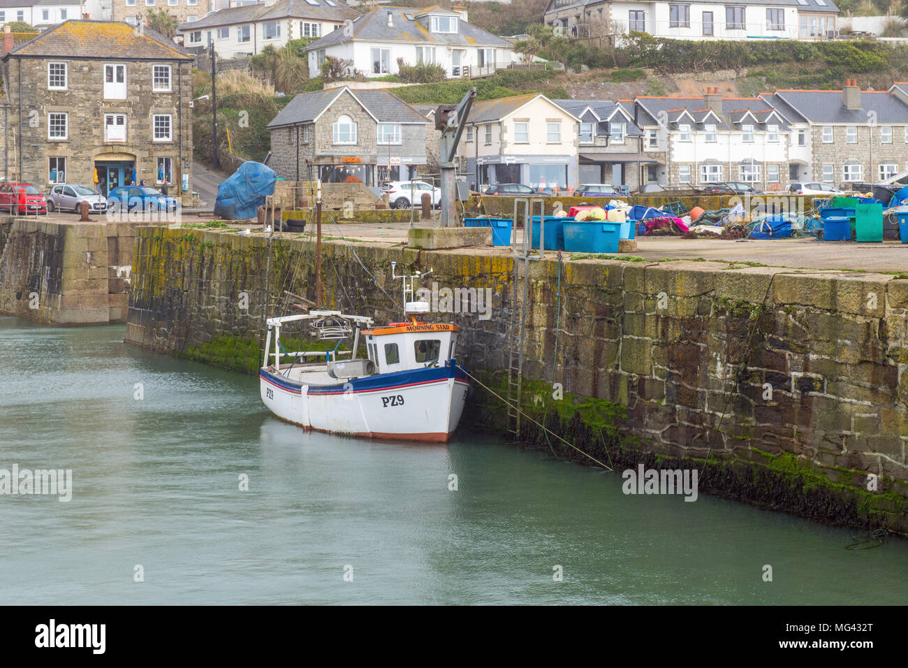 Fishing Boat moored up to harbour wall at Porthleven in Cornwall. Stock Photo