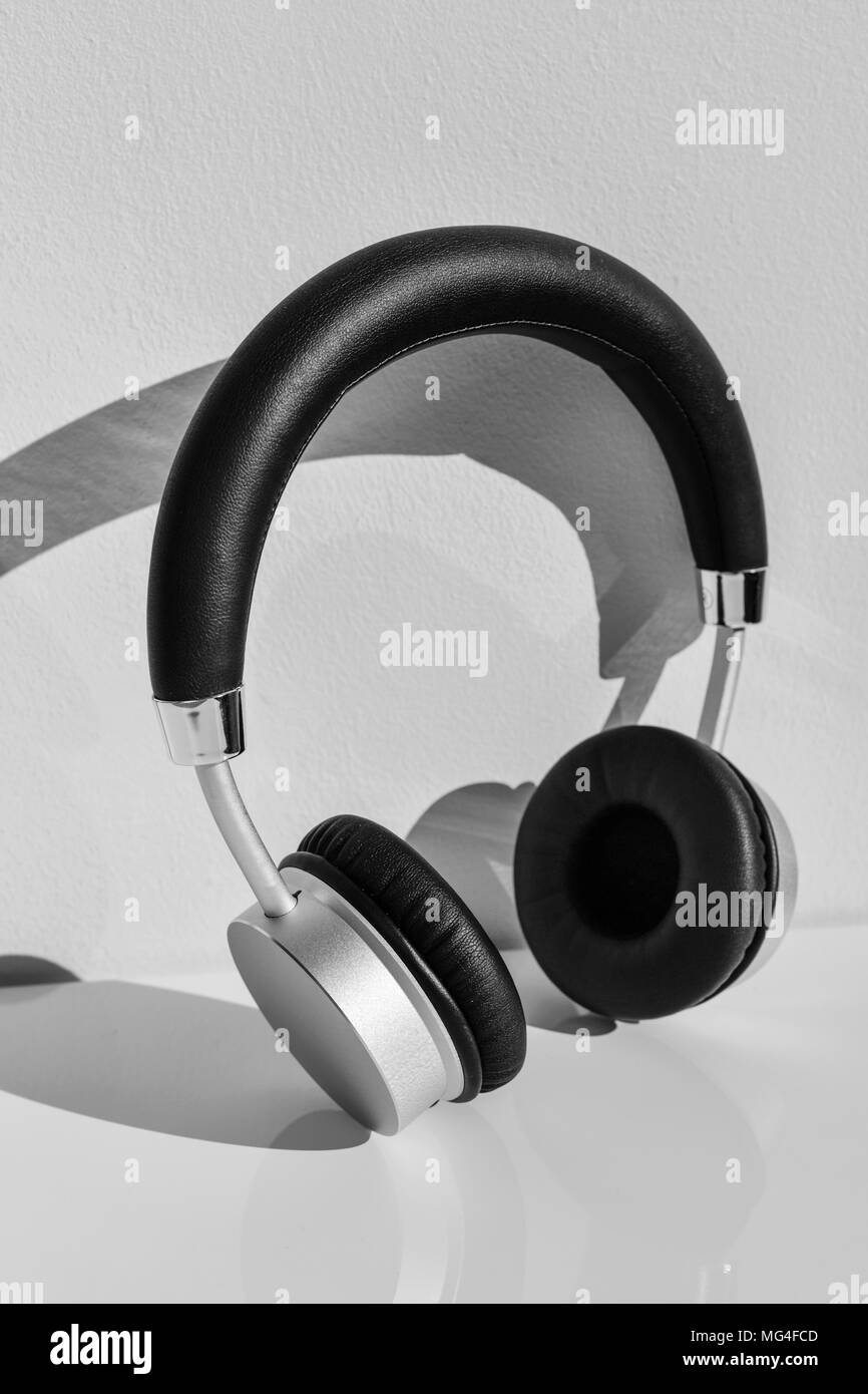 closeup of a pair of wireless headphones on a white table, against a white wall Stock Photo