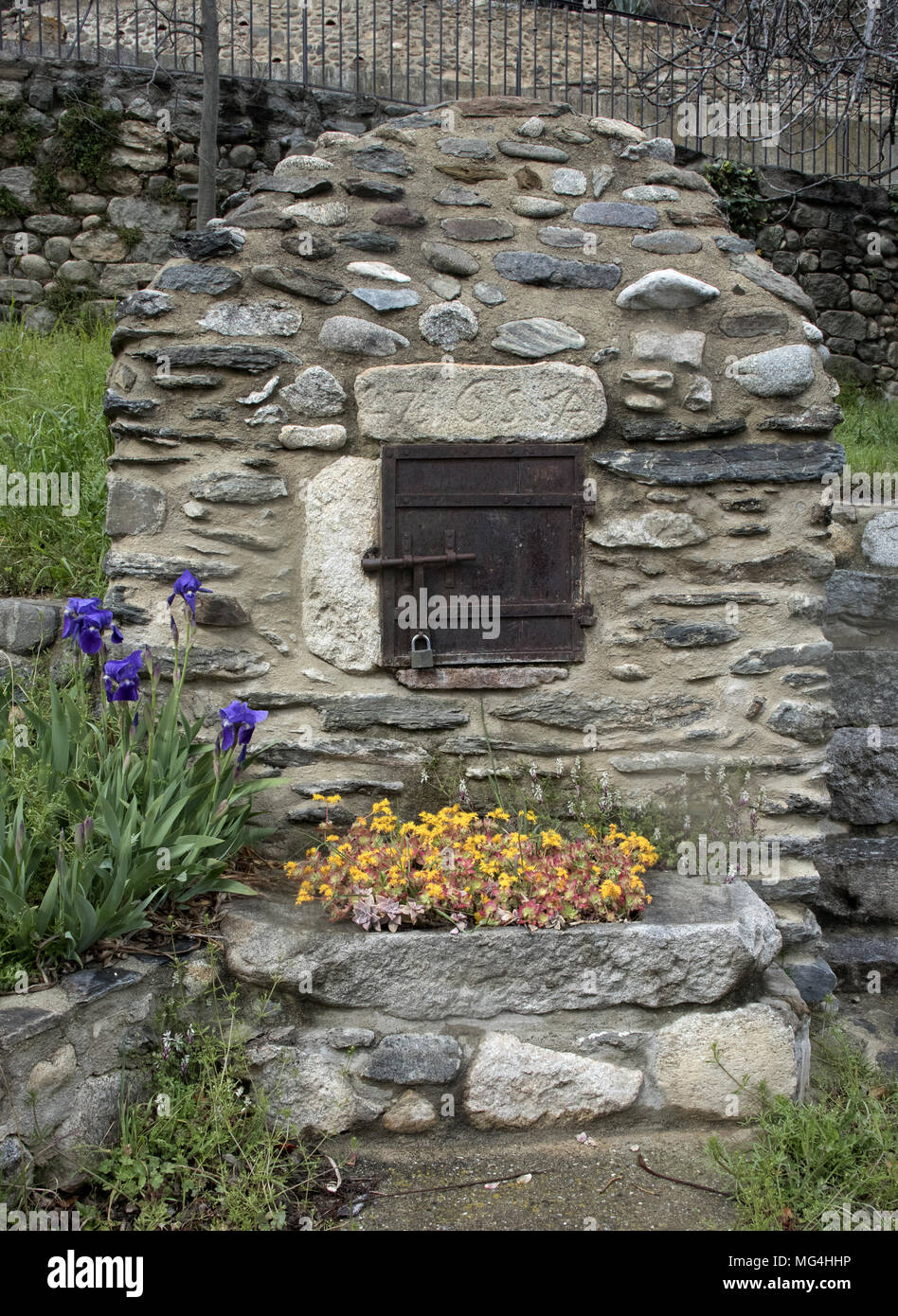 Old stone french oven in the village of Catllar, near Prades, with sedum and irises, Languedoc-Roussillon, Pyrénées-Orientales, France. Stock Photo