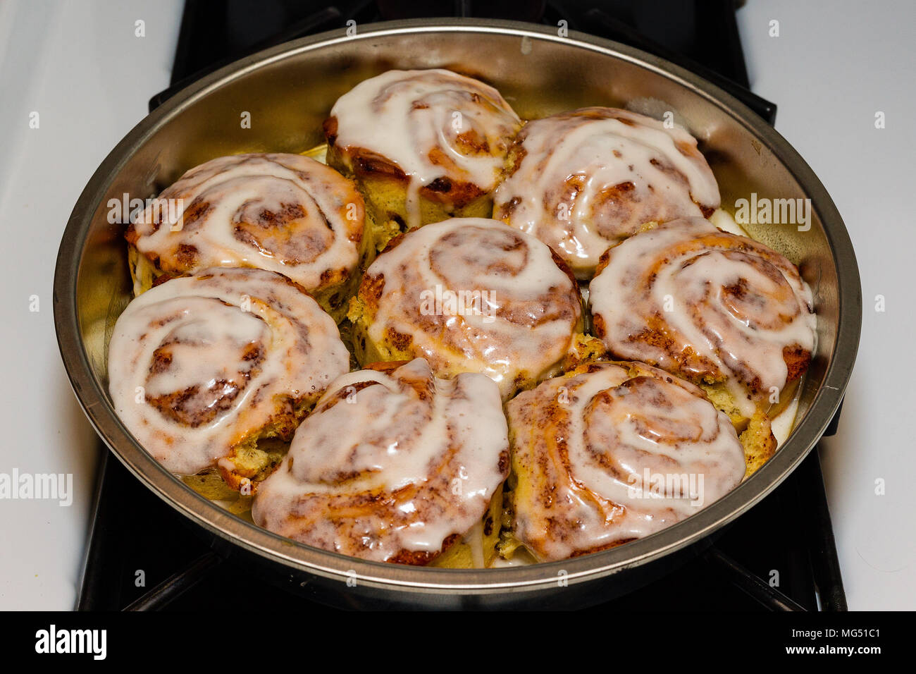 a pan of freshly baked and iced cinnamon rolls Stock Photo
